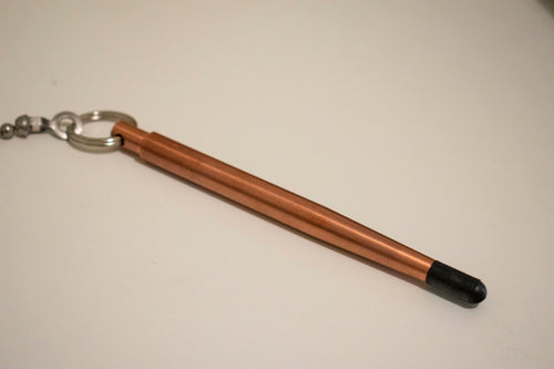 Copper stylus with black tip and keychain attachment on white background